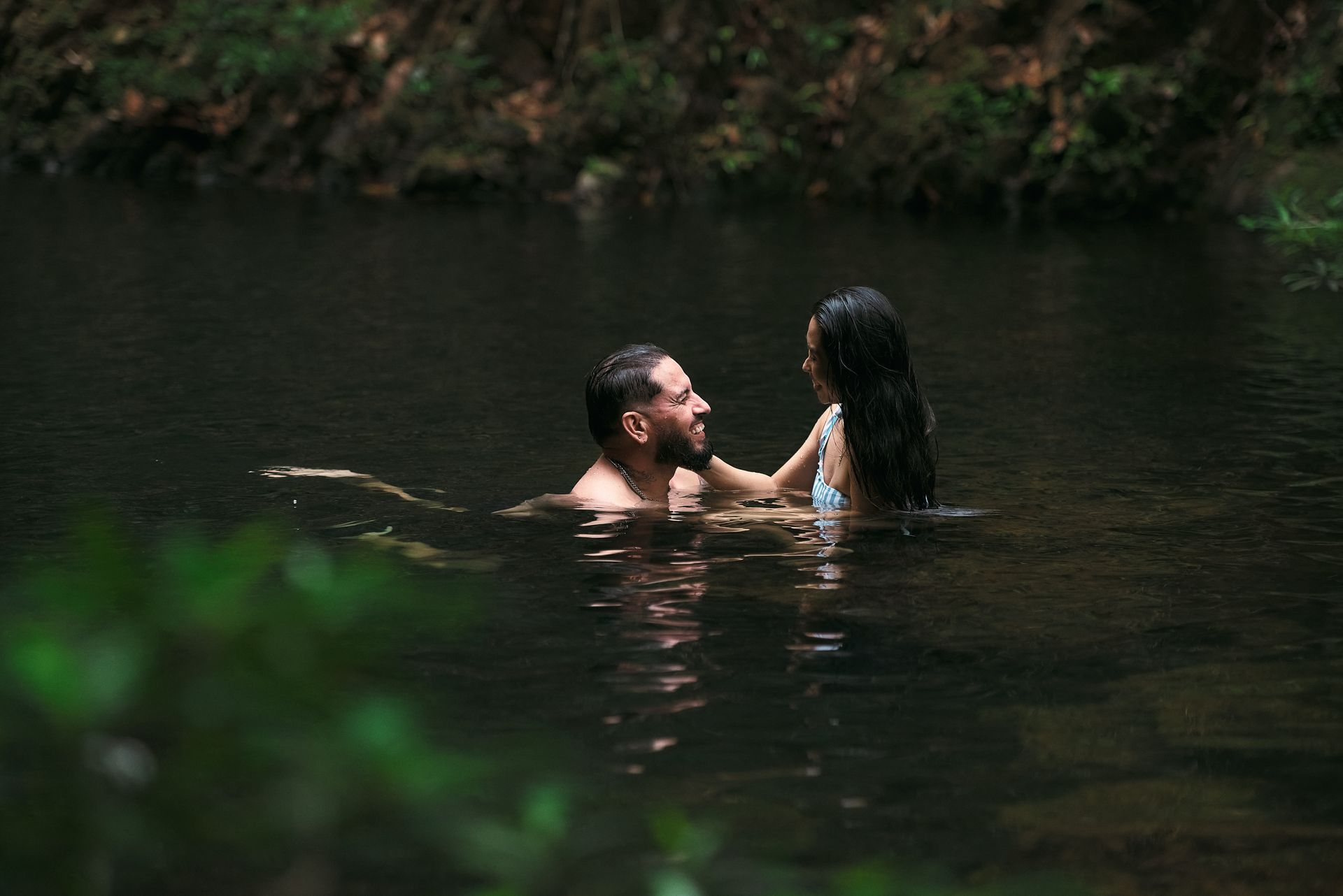 A man and a woman are swimming in a lake.