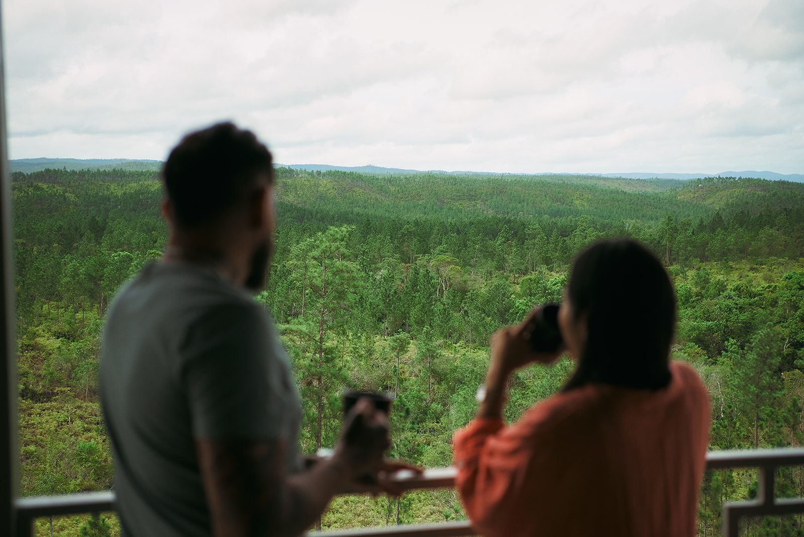 Couple savoring a peaceful moment with breathtaking views of the mountain and forest.