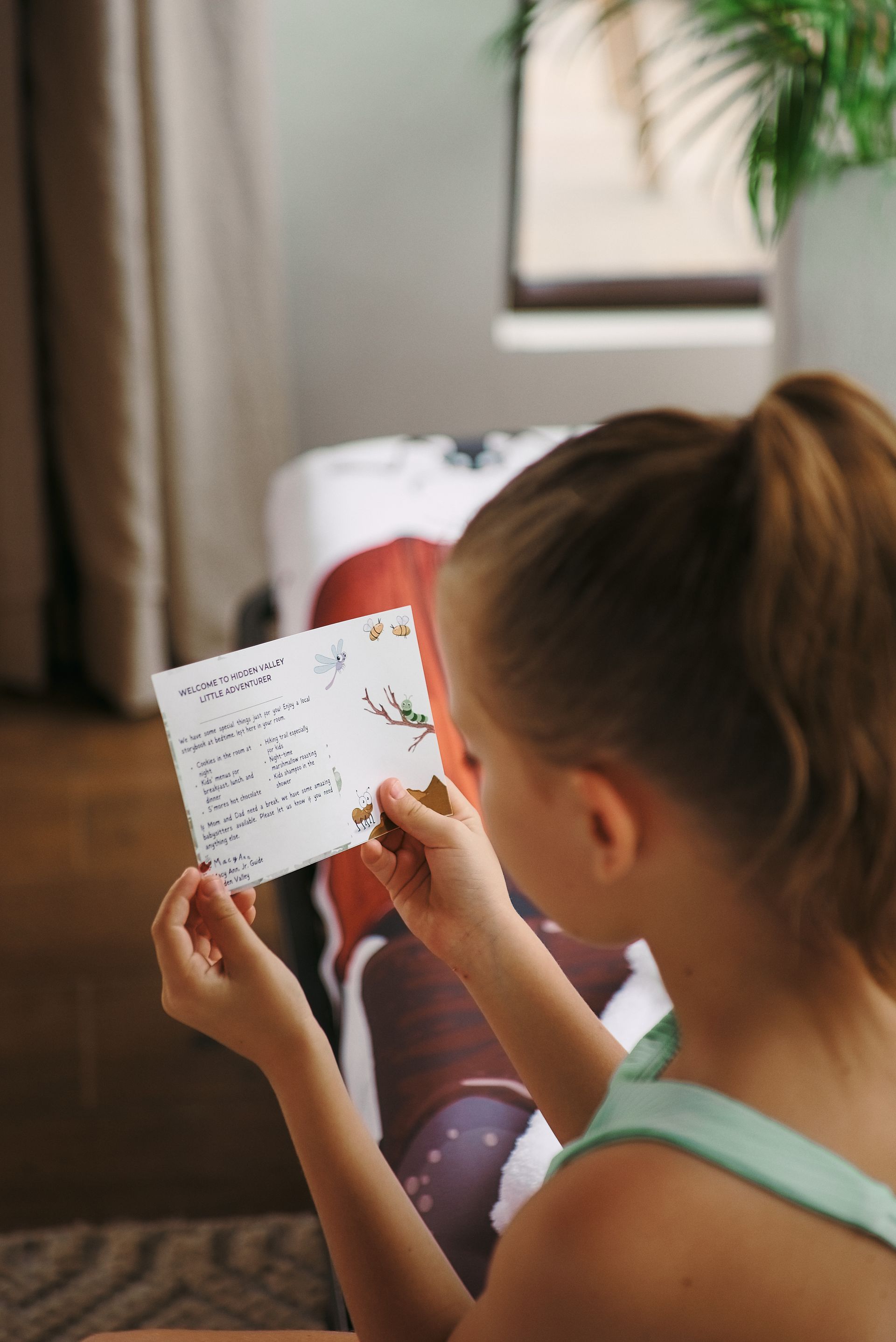 A little girl is holding a piece of paper in her hands.