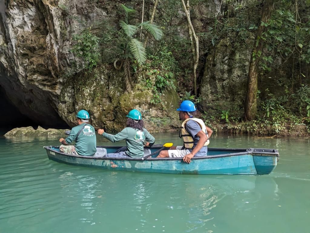 A group of people are in a canoe on a river.