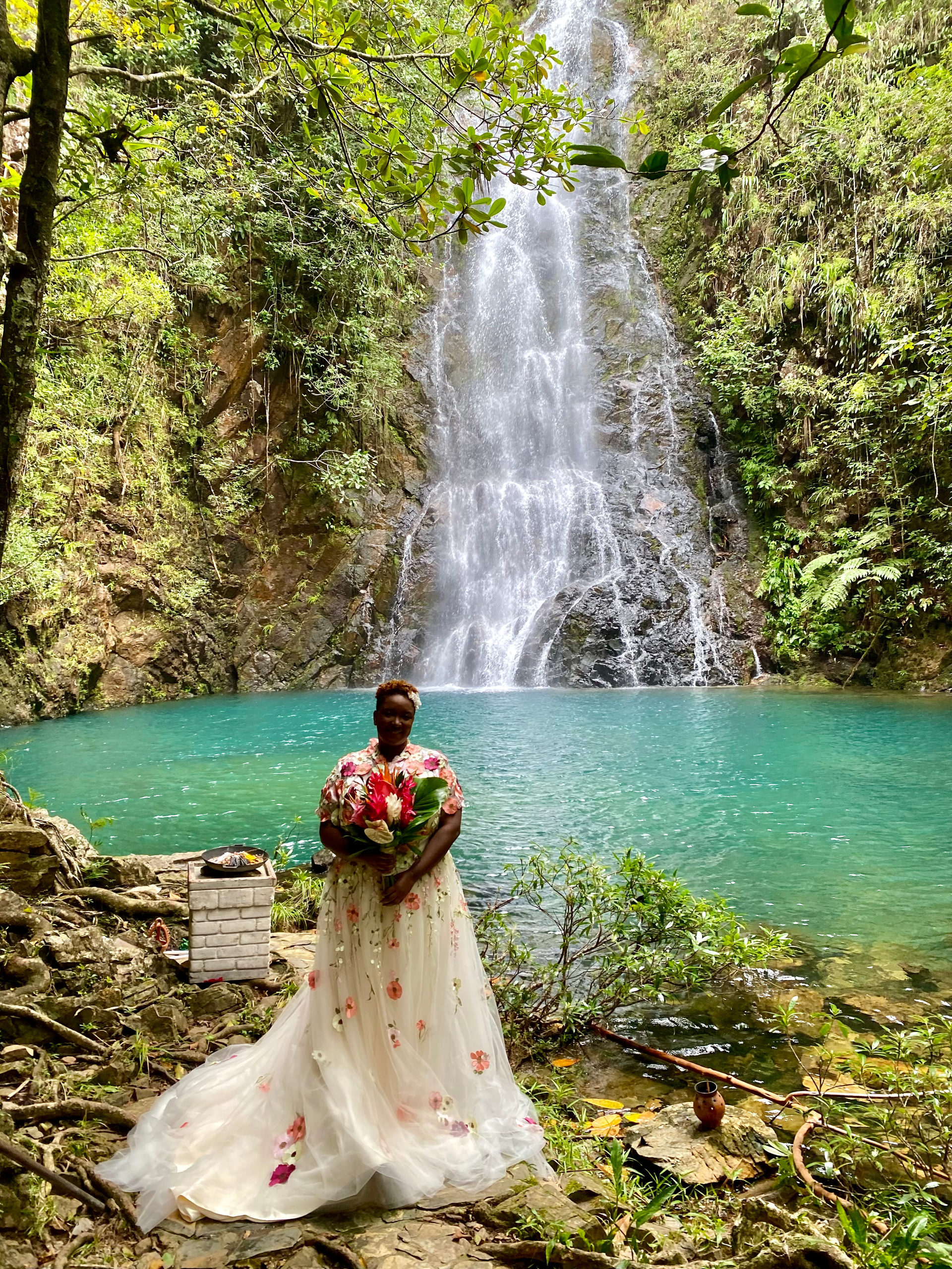 An enchanting wedding ceremony by the crystal-clear waters of Butterfly Falls, surrounded by lush greenery.