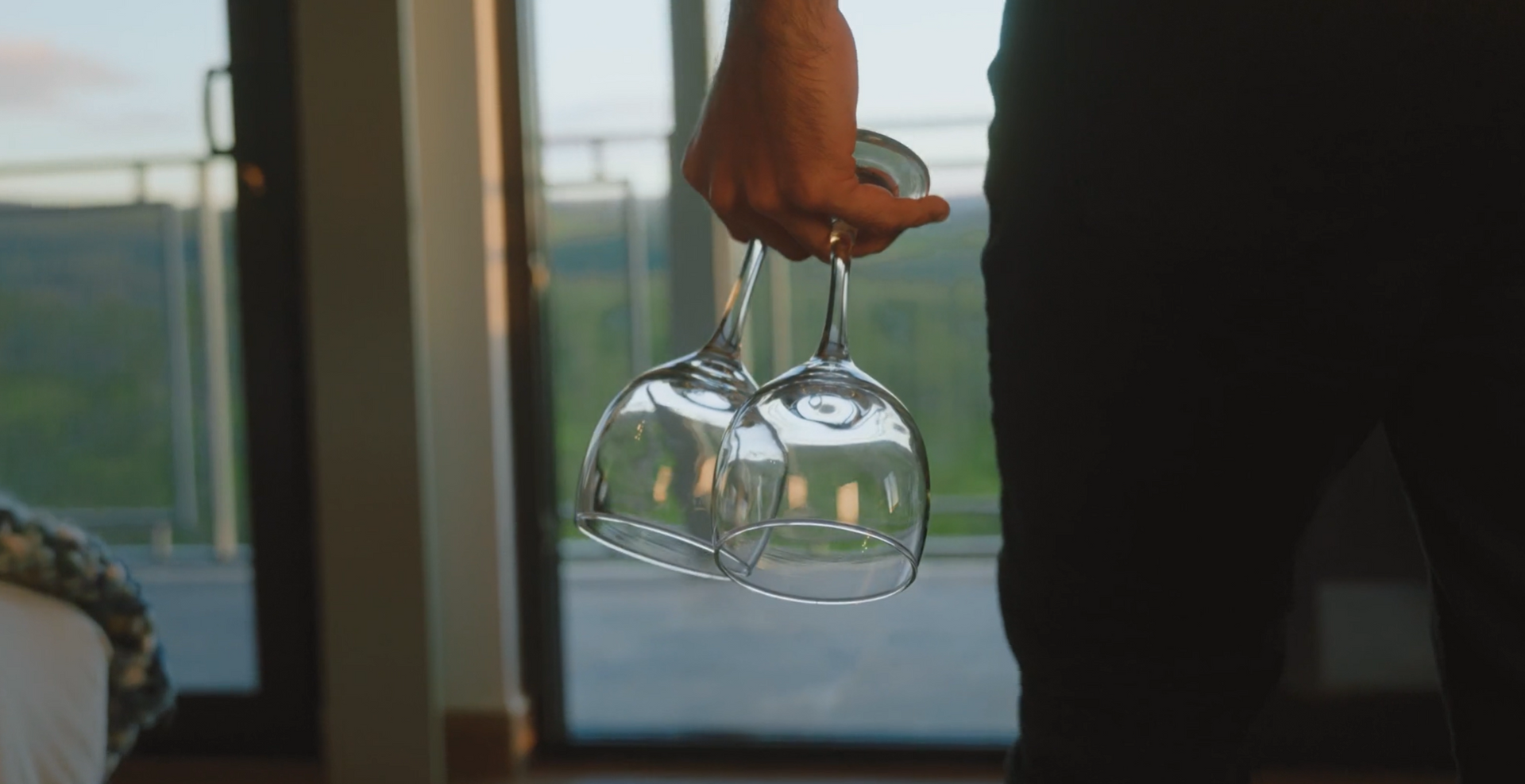 Couple enjoying a romantic moment with wine glasses at sunset, creating a perfect romantic getaway atmosphere.