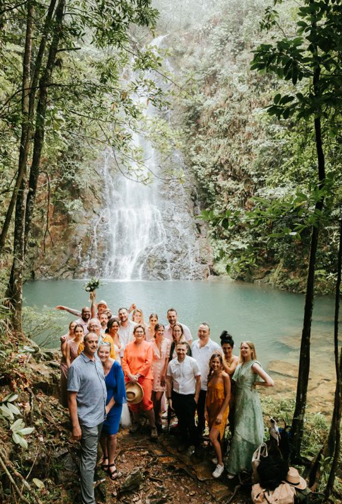 A small wedding party gathered at Butterfly Falls, celebrating love in a serene, natural setting.