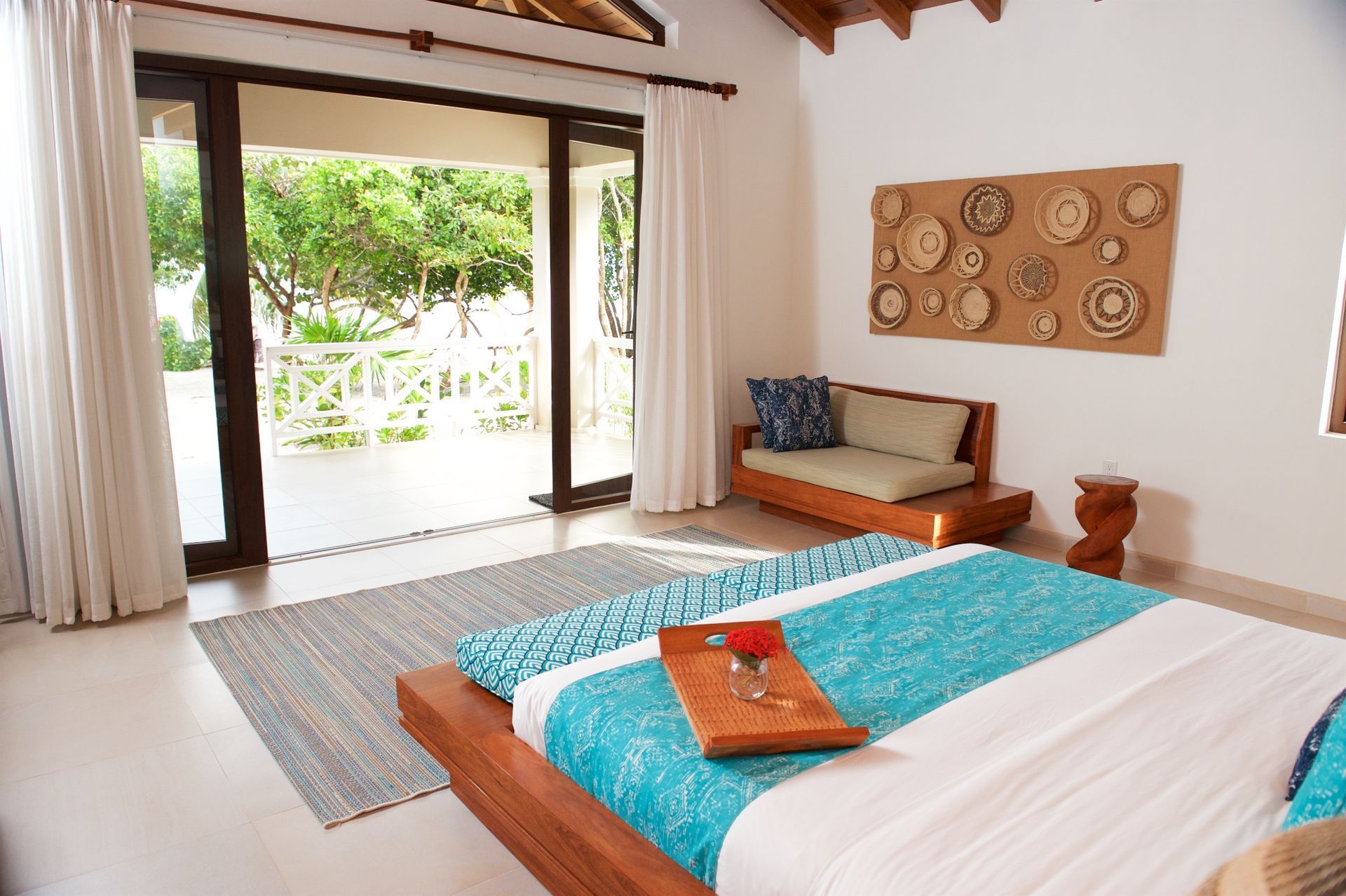 A bedroom with a bed , couch , and sliding glass doors leading to a balcony.