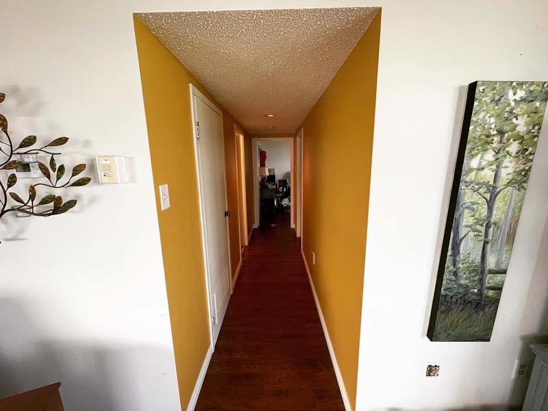 a long hallway with yellow walls and red carpet