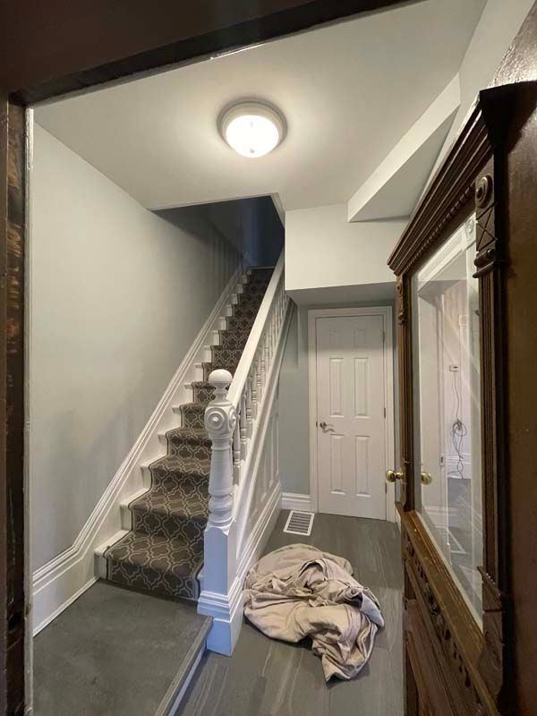 A hallway with stairs leading up to the second floor of a house.