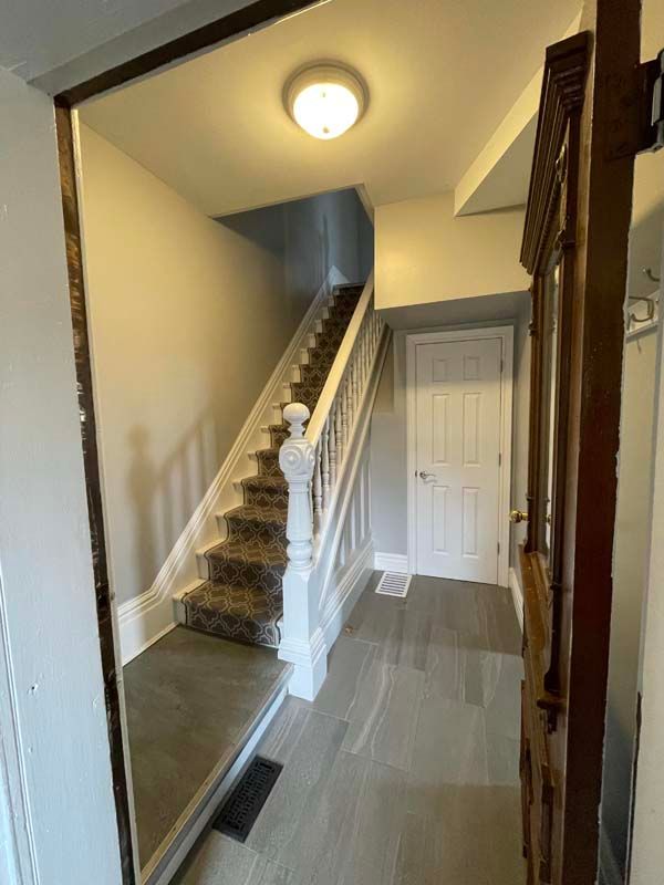 A hallway with stairs leading up to the second floor of a house.
