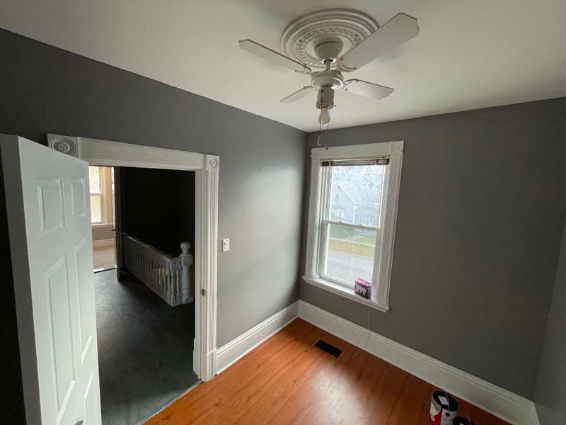 a room with a ceiling fan and a window .