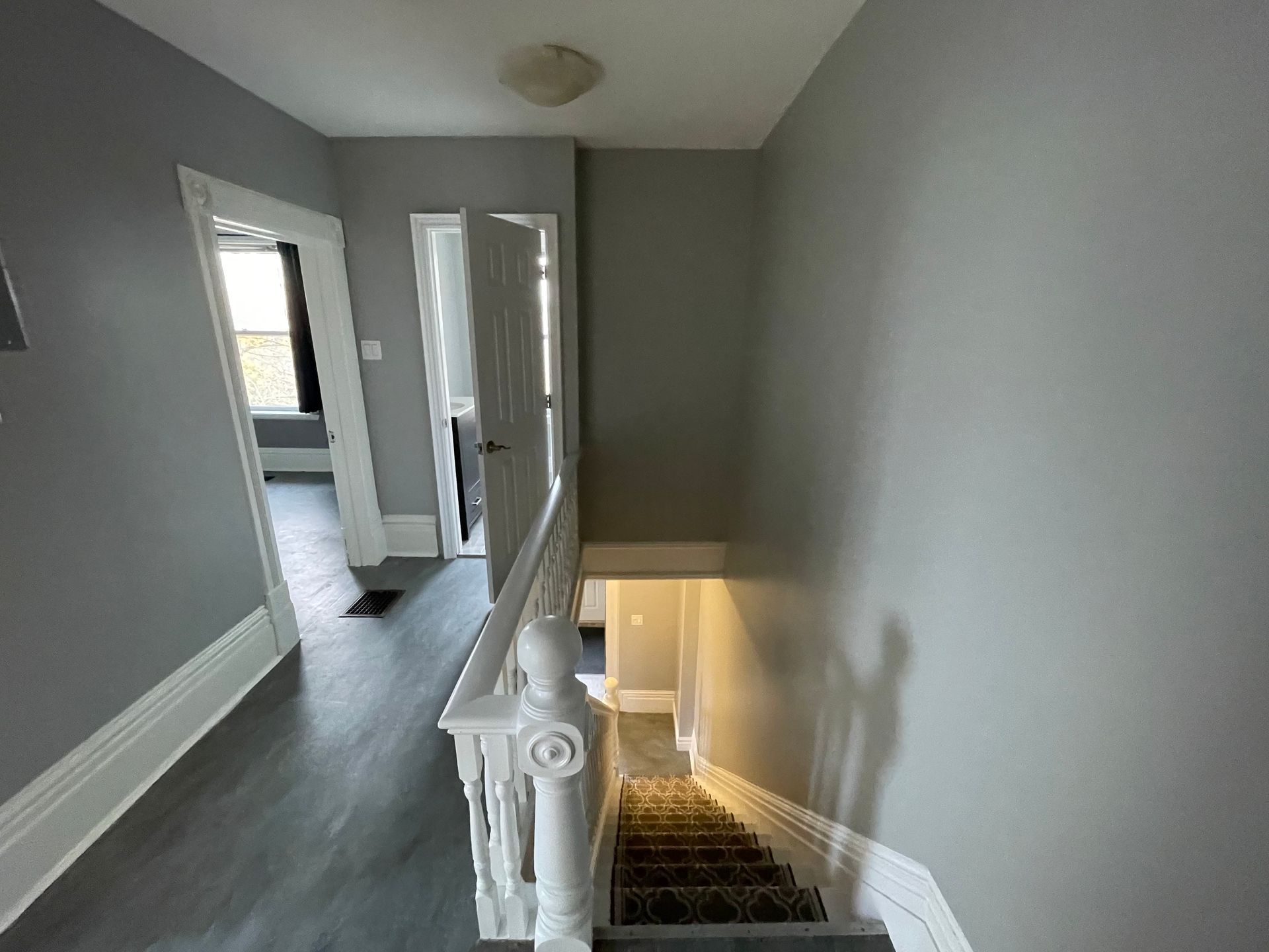 A hallway with stairs leading up to the second floor of a house.