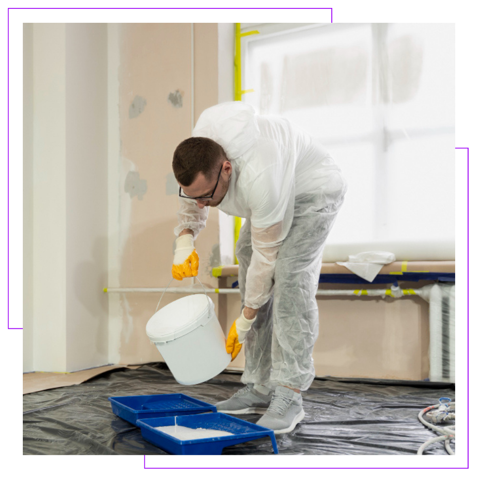 A man is painting a wall in a room.