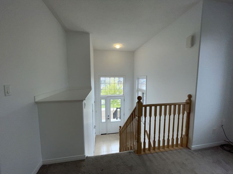 an empty hallway with stairs leading up to the second floor