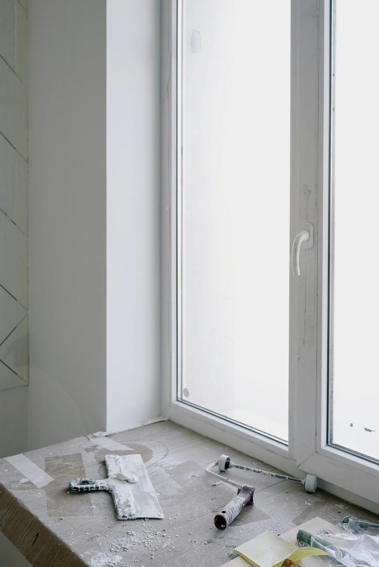 A window sill with a spatula and a tube of paint on it.