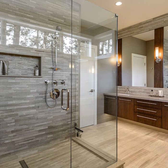 A bathroom with a walk in shower and a sink.