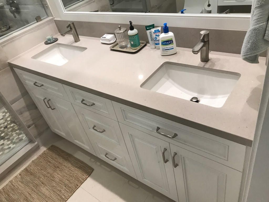 A bathroom with two sinks and a mirror.