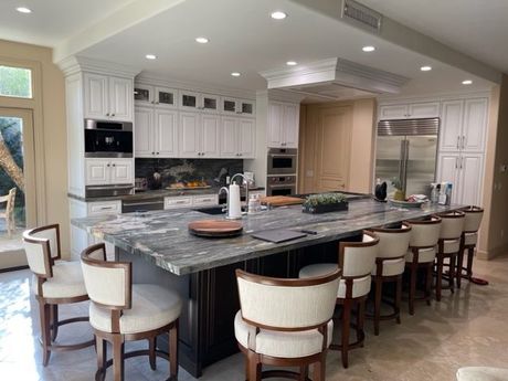 A kitchen with a large island and lots of chairs