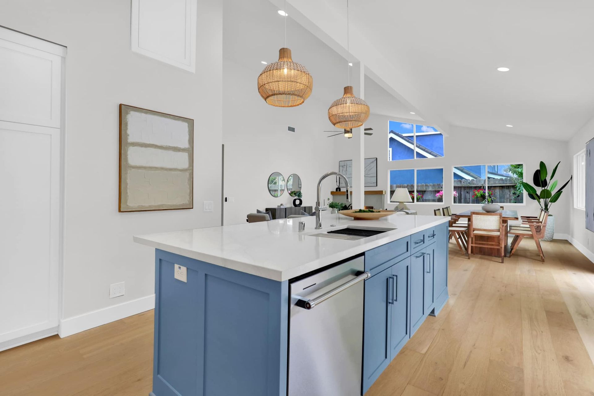 A kitchen with blue cabinets , white counter tops , and a large island.