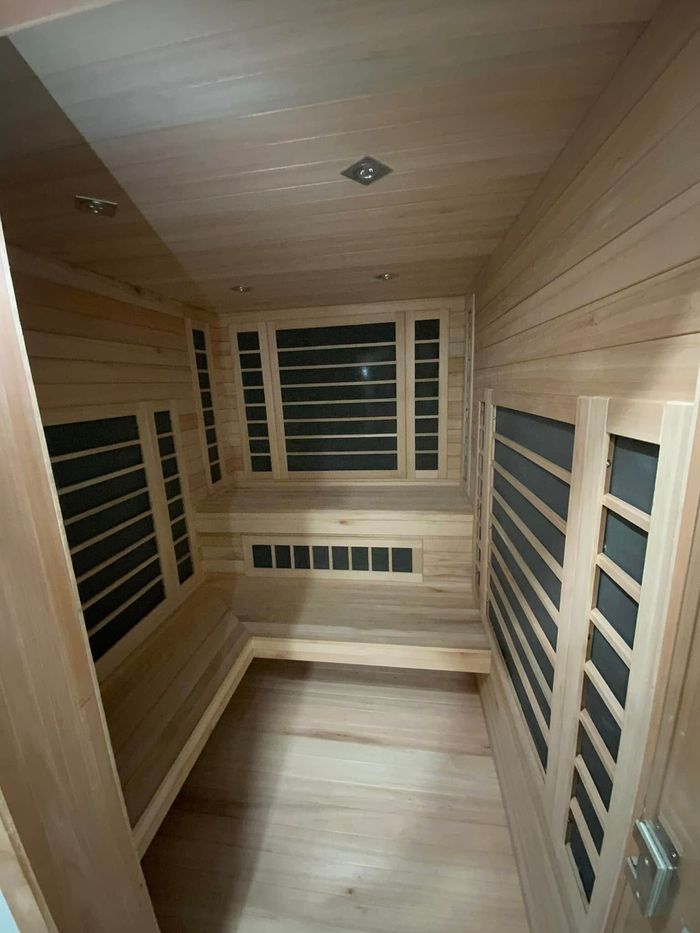 A wooden sauna with black windows and a wooden floor.