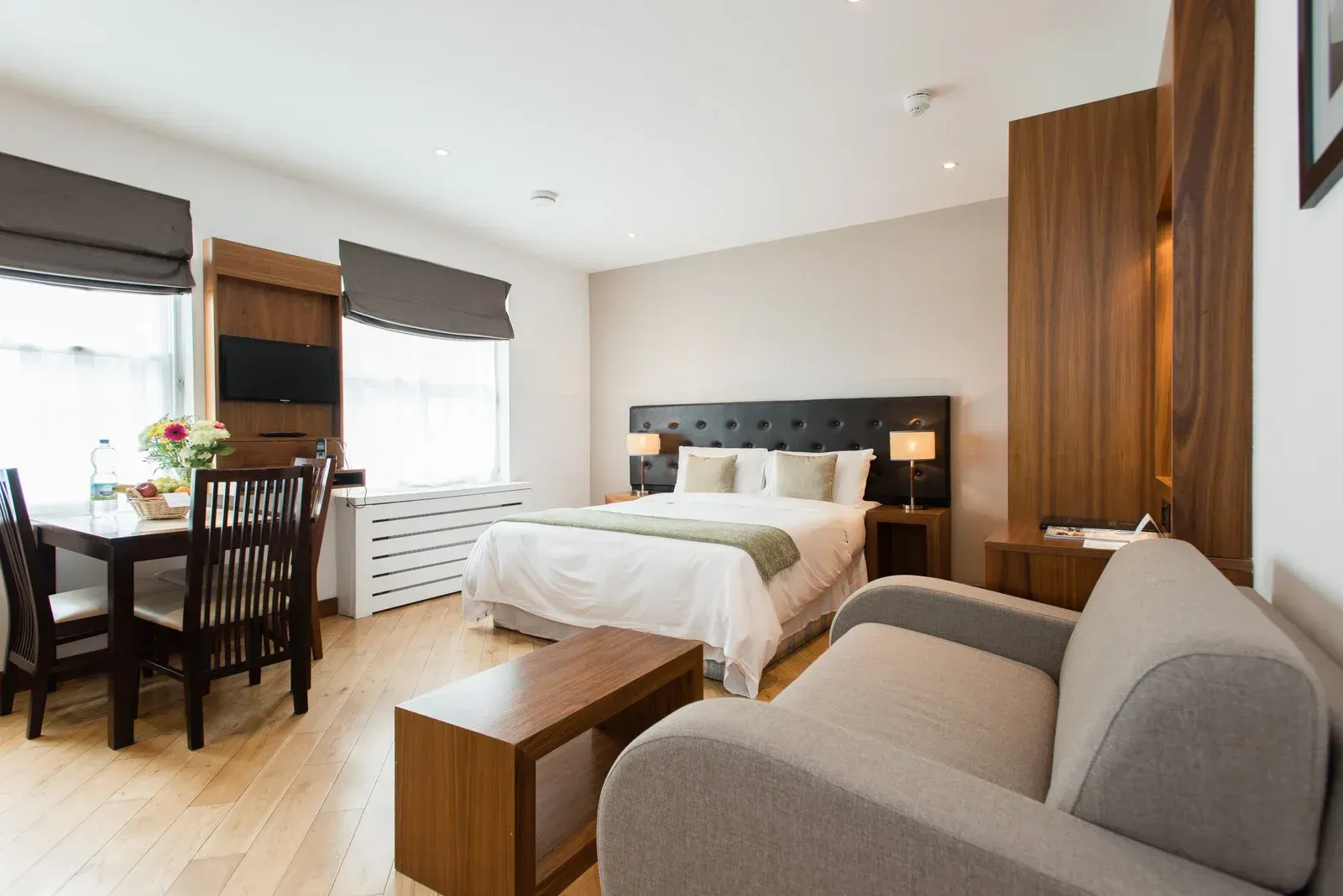 A hotel room with a bed , couch , table and chairs