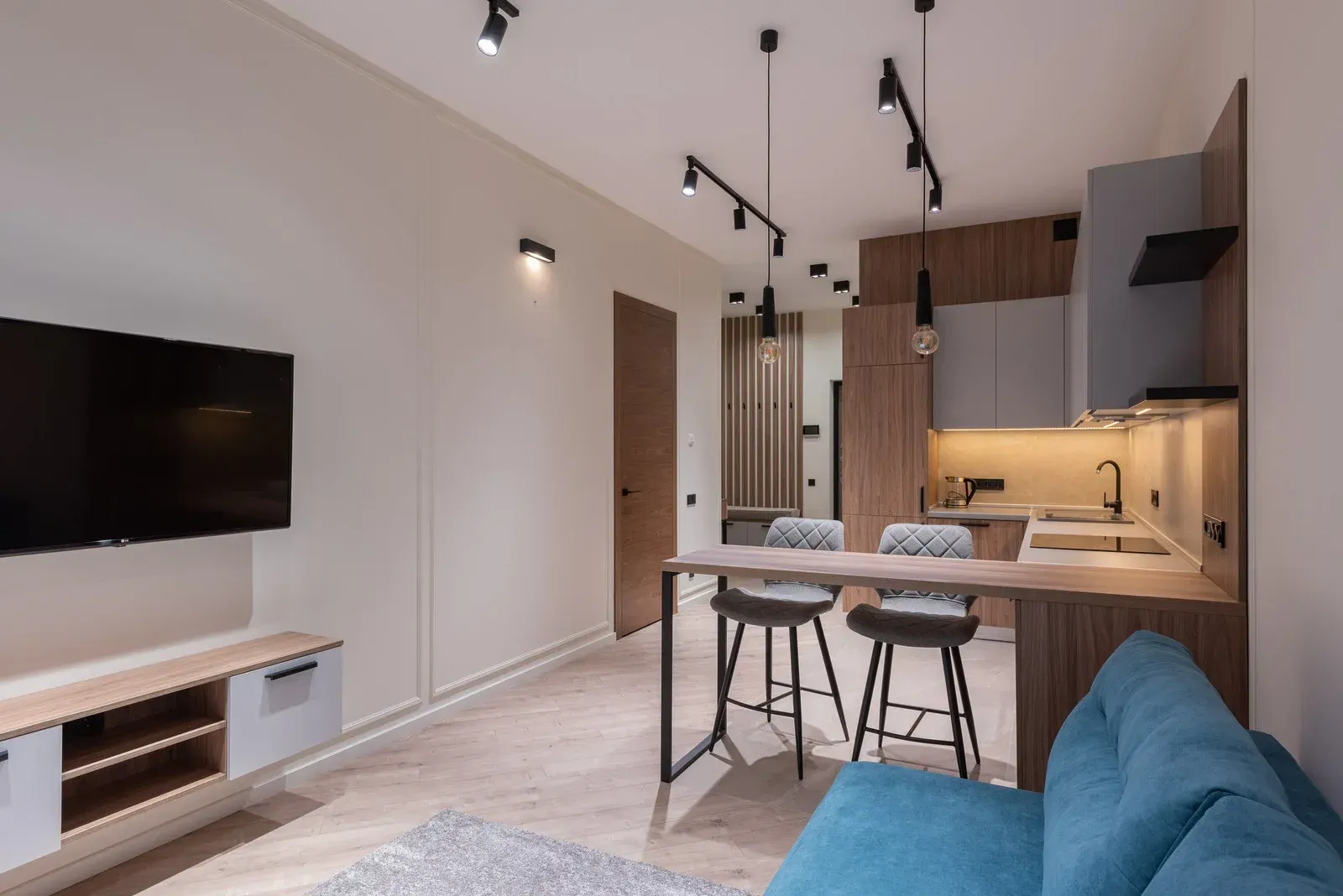 A living room with a blue couch and a flat screen tv.