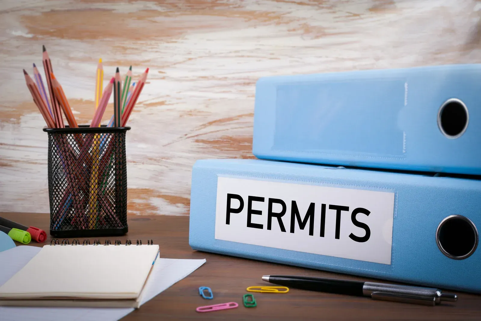 A stack of blue binders with the word permits written on them.