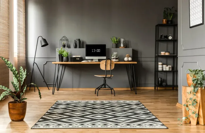 There is a desk with a computer on it in the middle of the room.