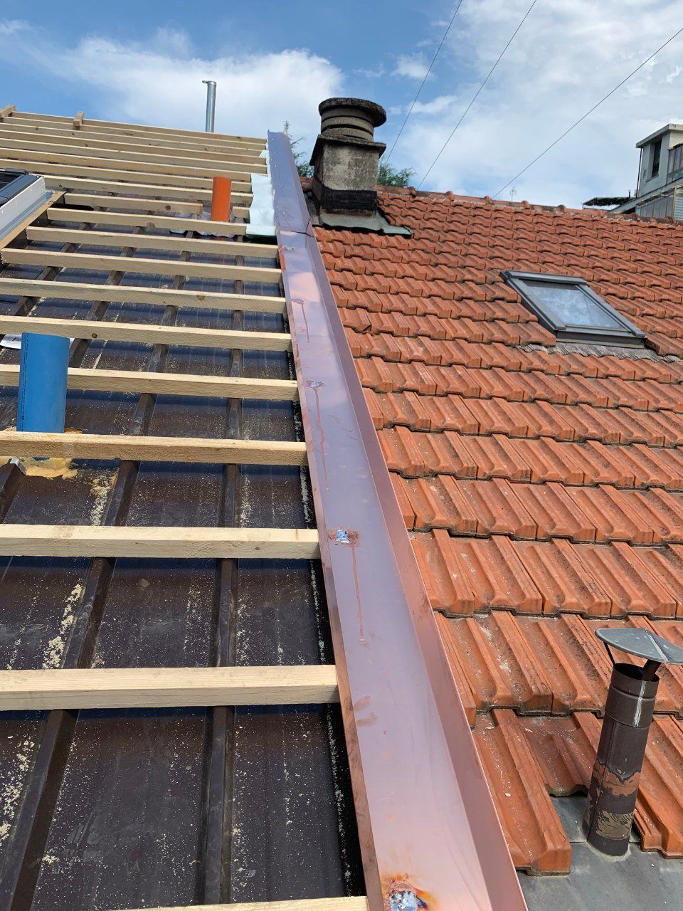 tecnici sul tetto di una abitazione mentre installano una grondaia