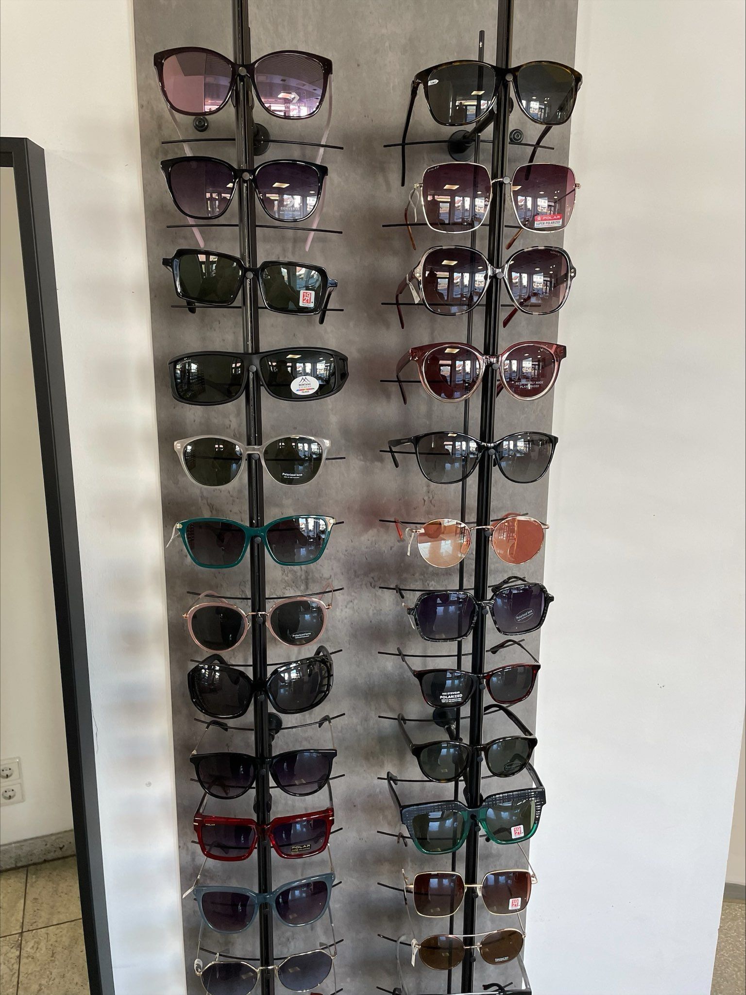 eine Reihe von Sonnenbrillen hängt an einem Ständer
