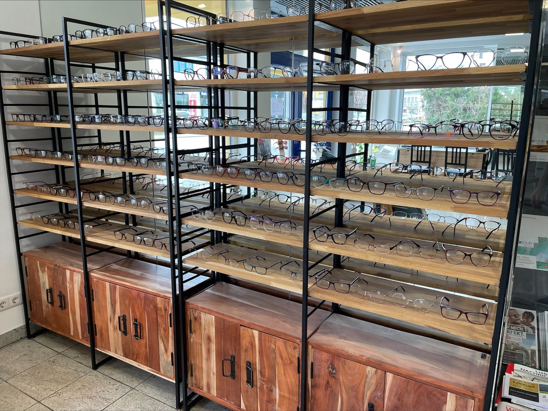 eine Reihe von Holzregalen mit Brillengläsern darauf