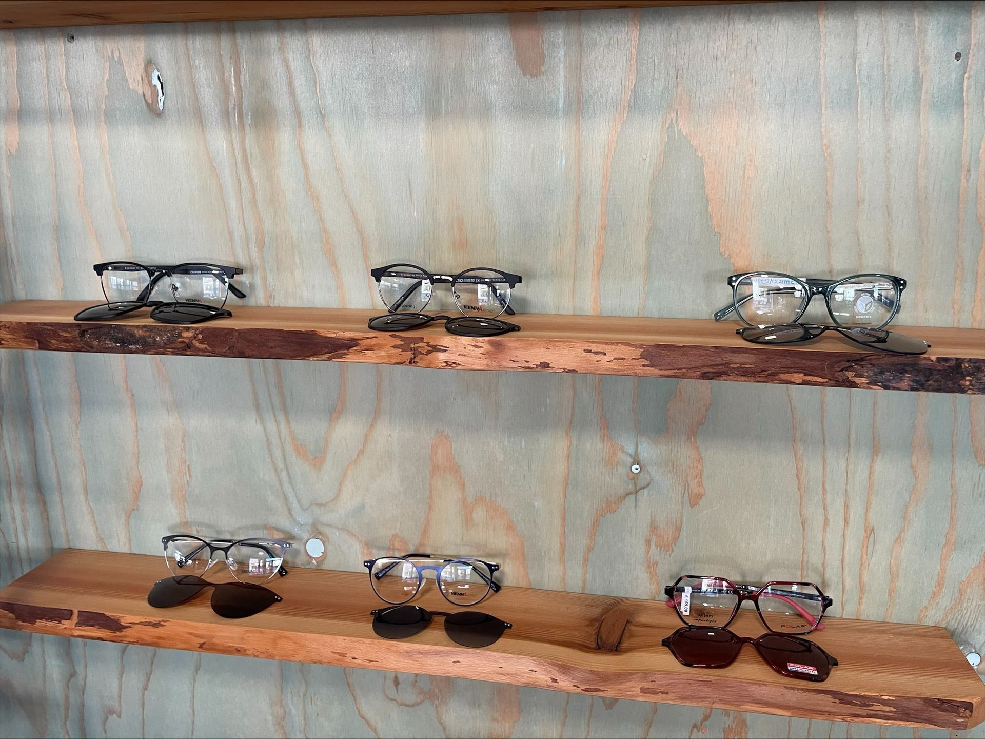 eine Auswahl an Brillengläsern auf einem Holzregal