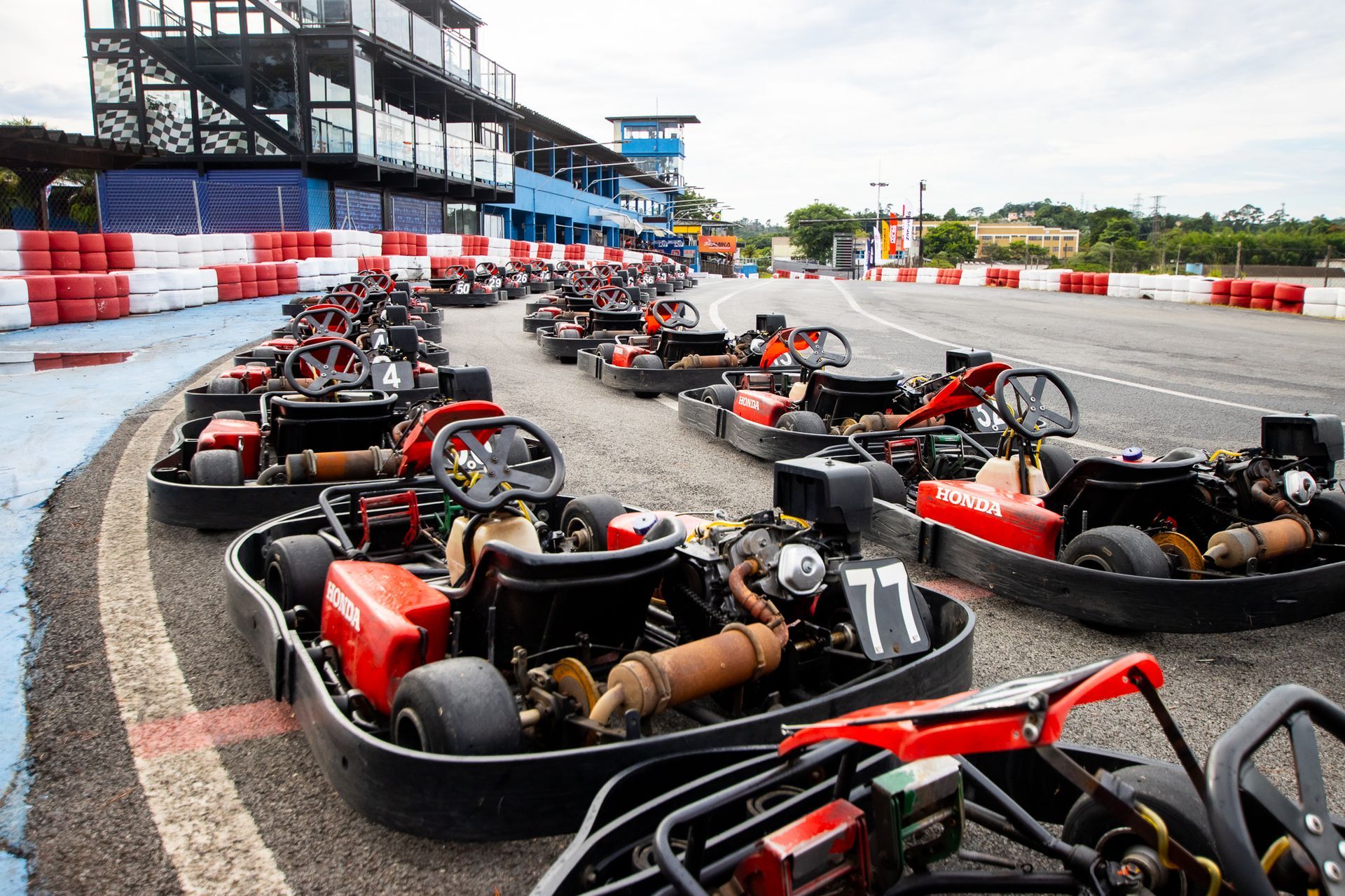 Uma fila de karts está estacionada em uma pista de corrida.