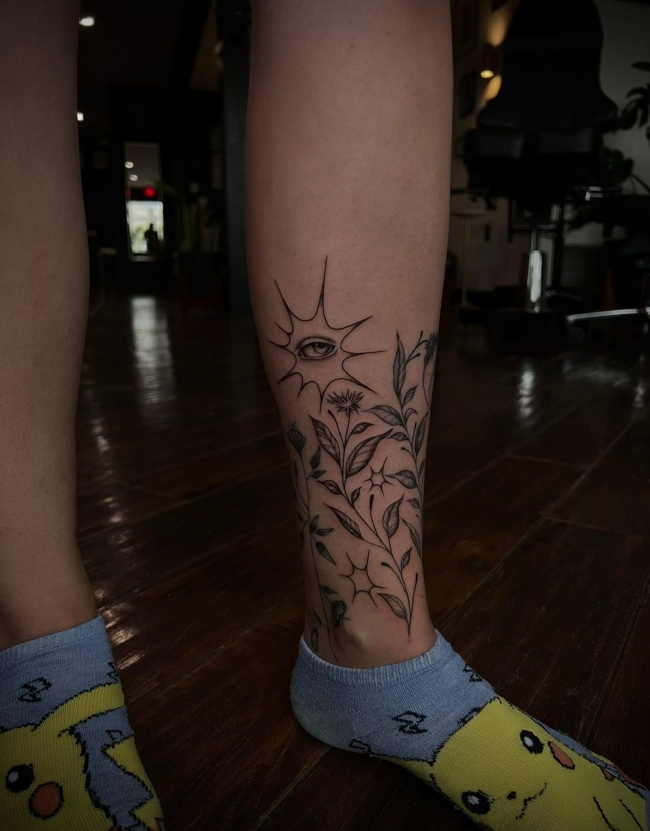A person with a tattoo on their leg wearing socks.