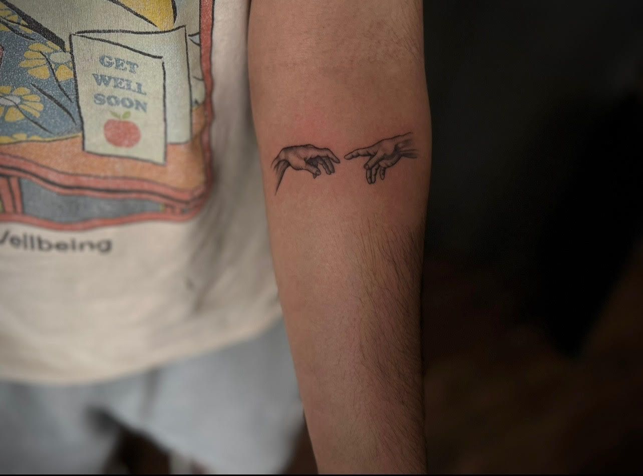 A person with a tattoo on their arm that says `` get well soon ''.