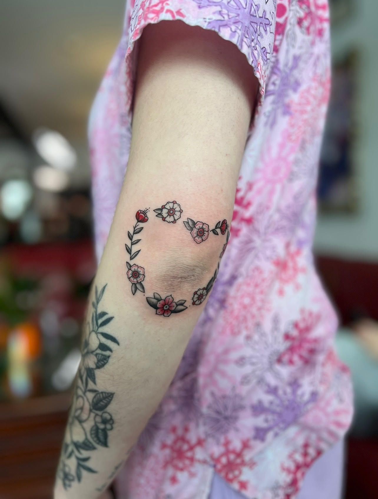 A woman has a heart tattoo on her elbow.