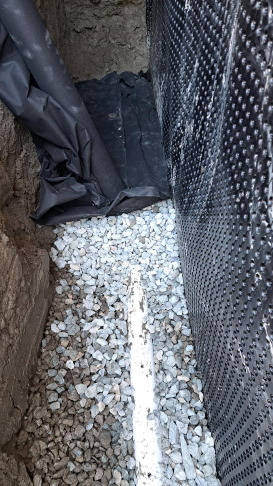 Un tas de gravier est posé à côté d'un mur.