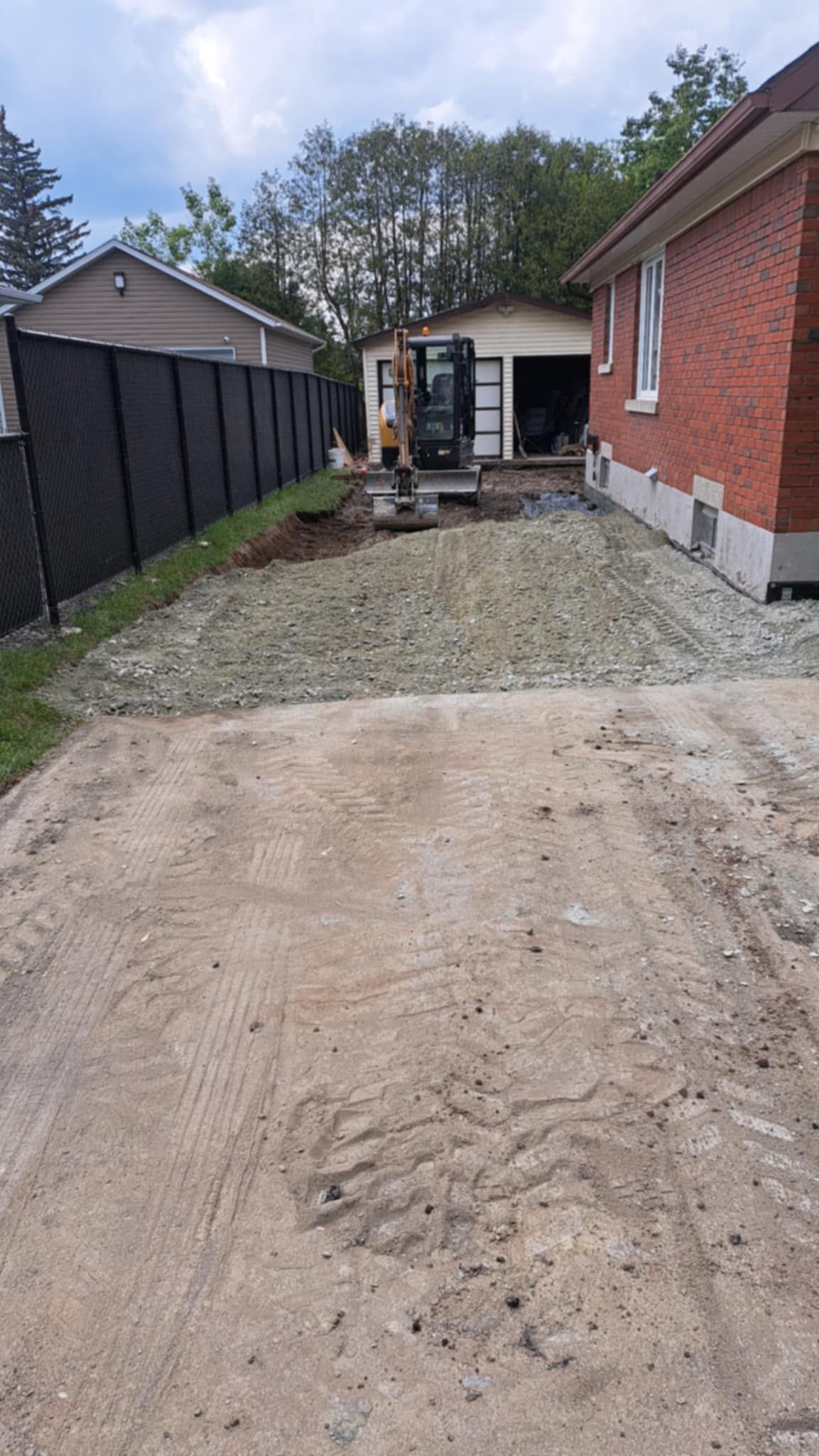 Une maison en briques avec une allée de gravier devant elle.
