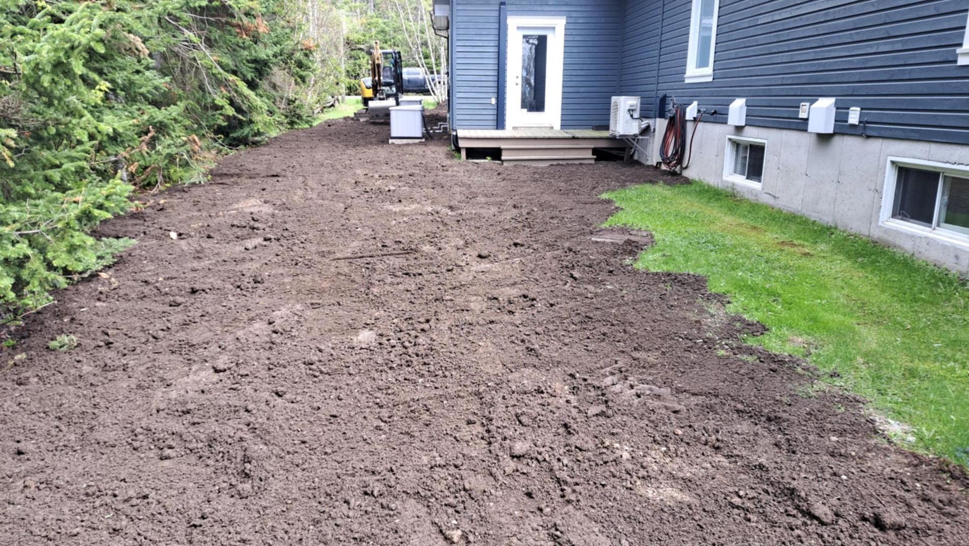 Un chemin de terre menant à une maison avec beaucoup de terre devant elle.