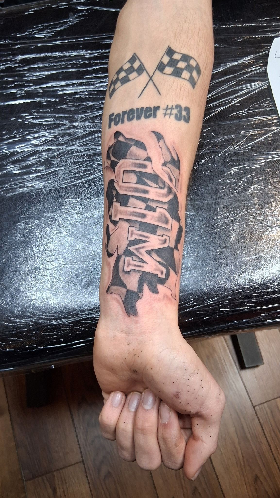 Arm tattoo with checkered flags, 