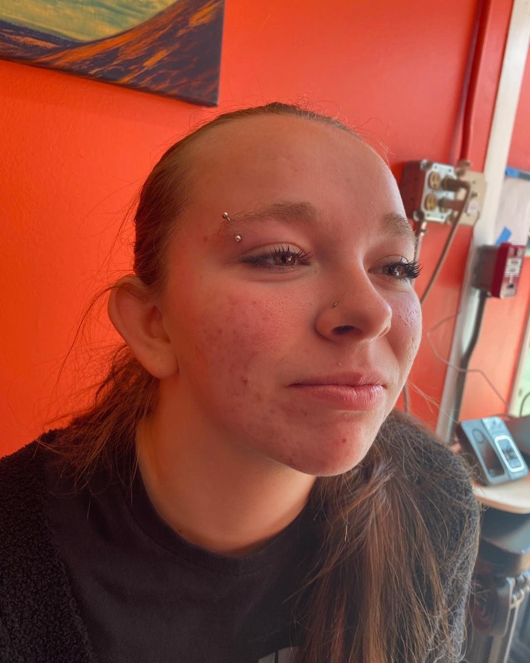Woman wearing large glasses, looking upwards, in a shop with displays.