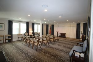 A large room with rows of chairs and a podium.