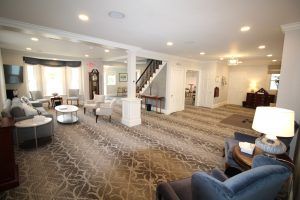 A living room with a lot of furniture and a clock on the wall.