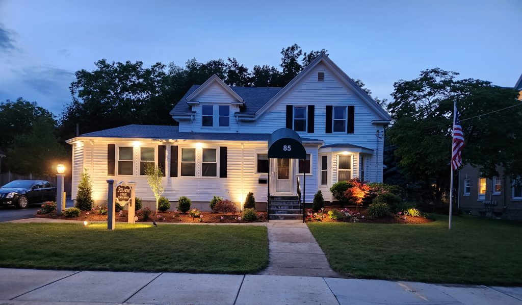 A large white house is lit up at night