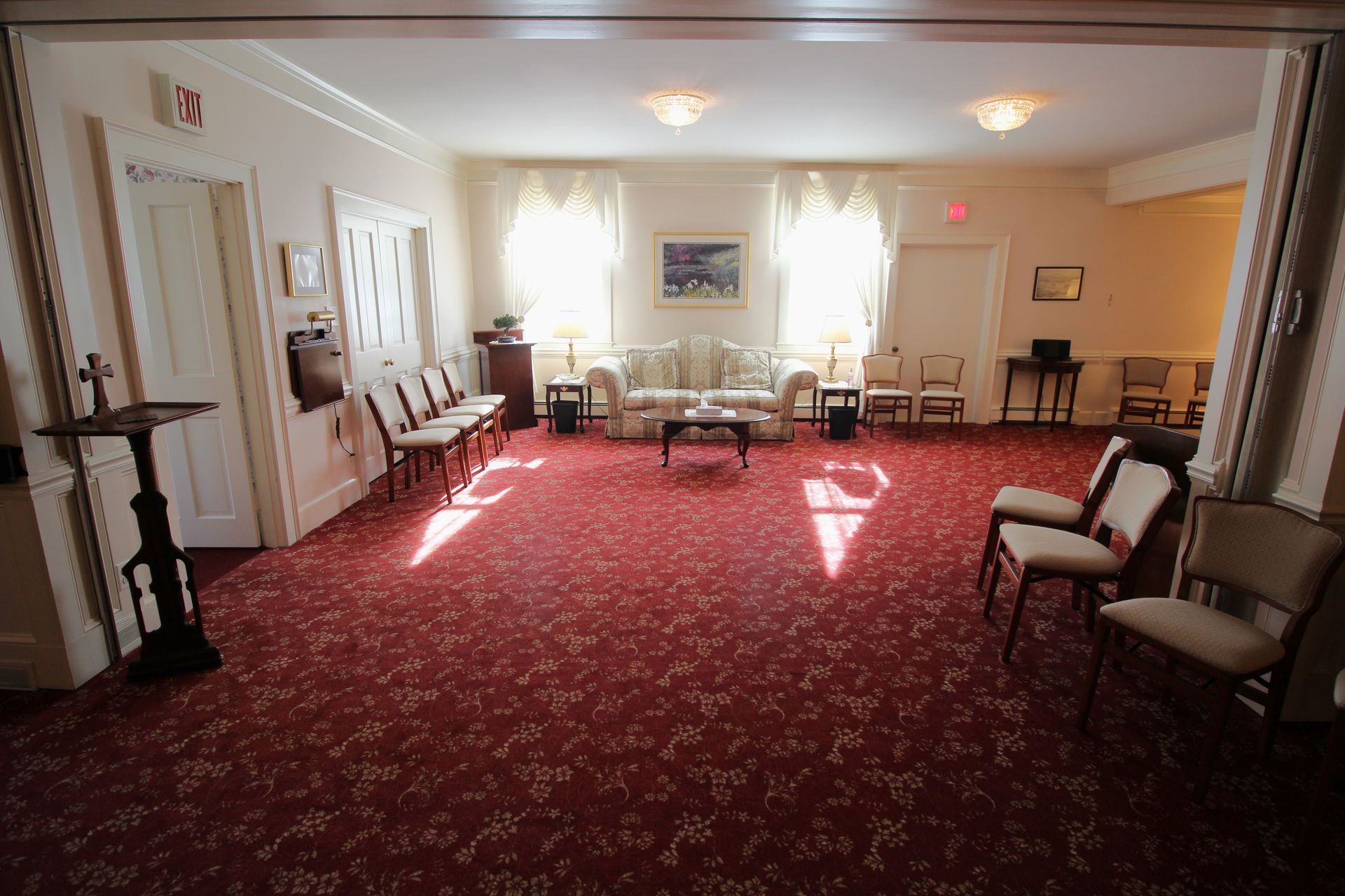 A large room with a red carpet and chairs