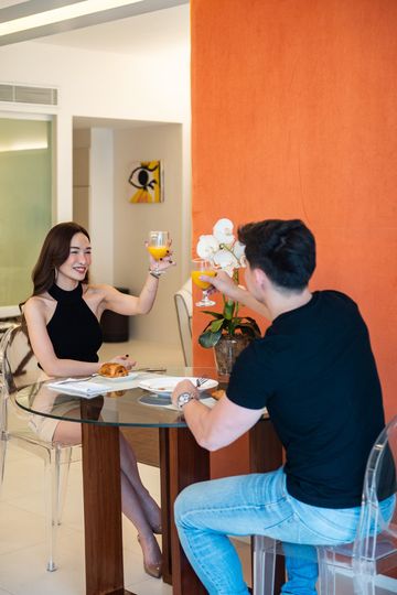 Couple enjoying in-room dining service at Makati boutique hotel suite with modern decor