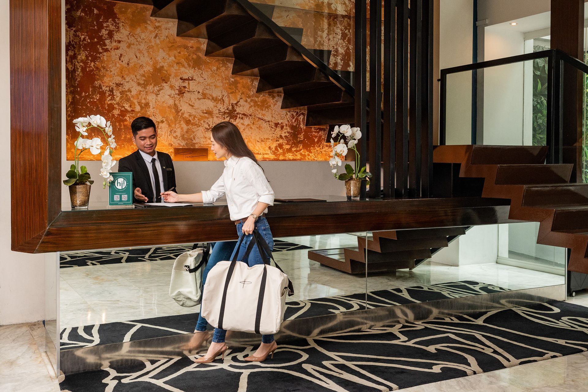 Guest checking in at illuminated reception desk of Makati boutique hotel