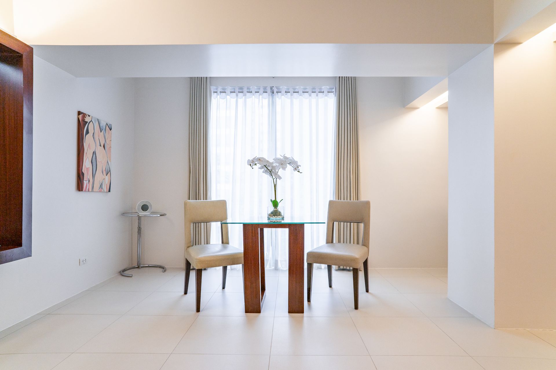 A dining room with two chairs and a glass table