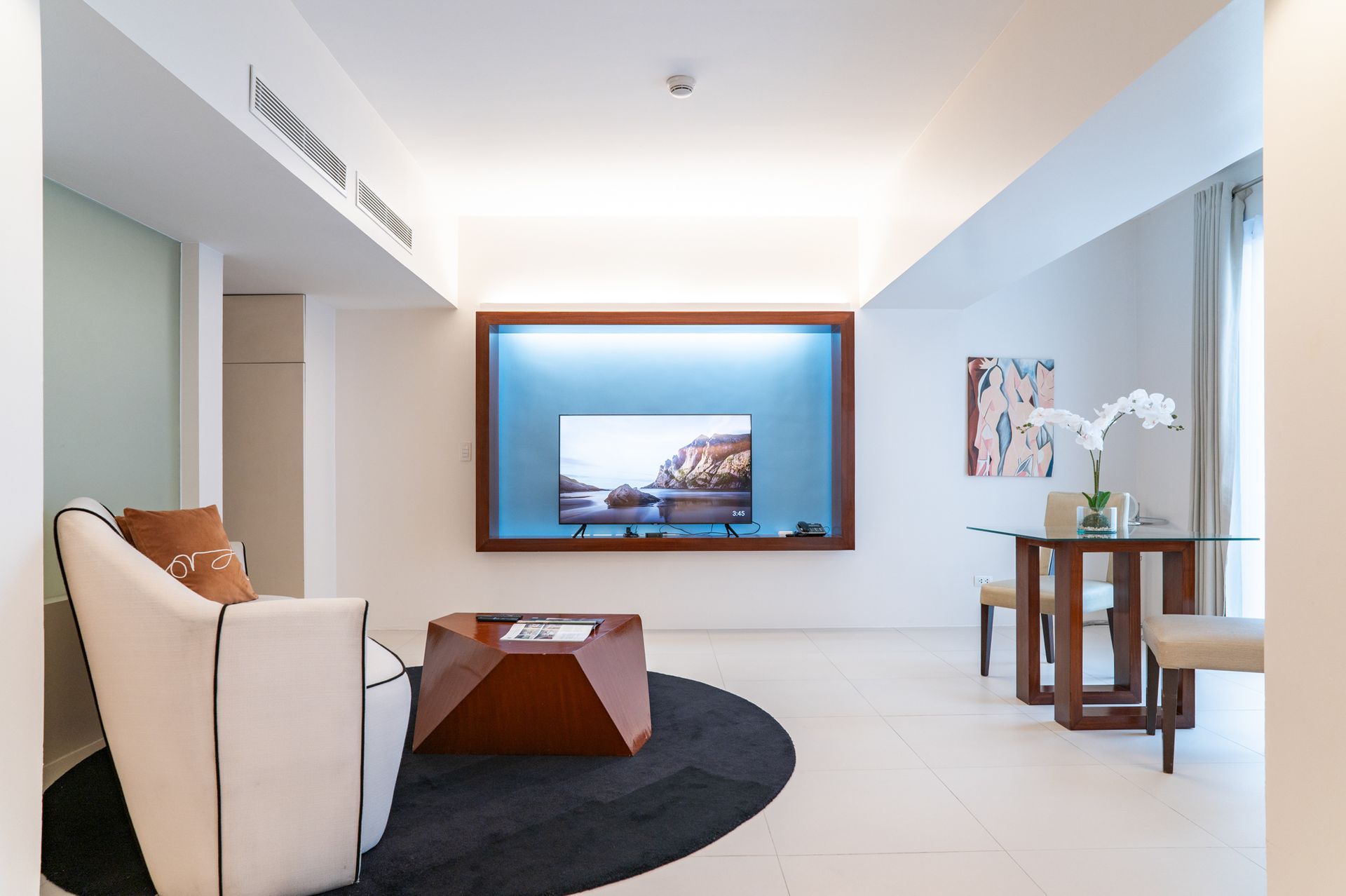 A living room with a large flat screen tv on the wall