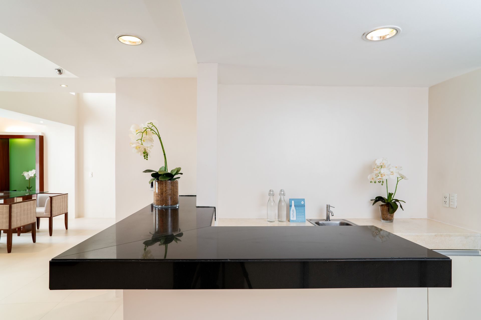 A black counter top with a vase of flowers on it