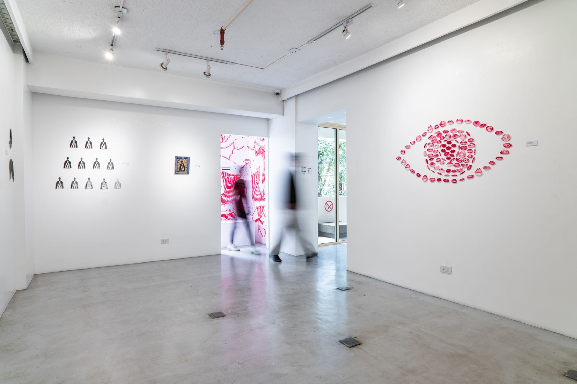 Contemporary art gallery with red eye installation and blurred visitors