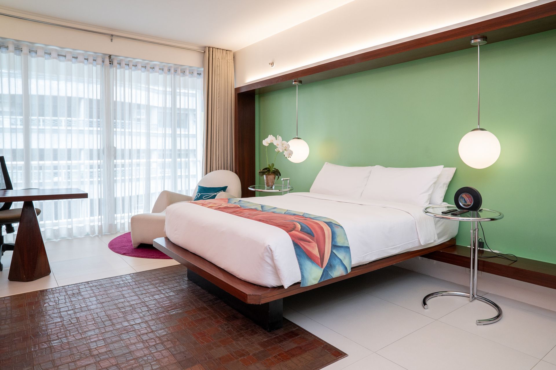 A hotel room with a large bed and a green wall