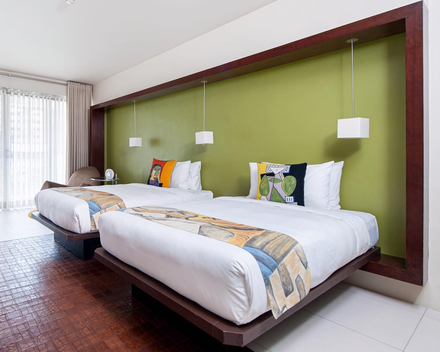 A hotel room with two beds and a green wall